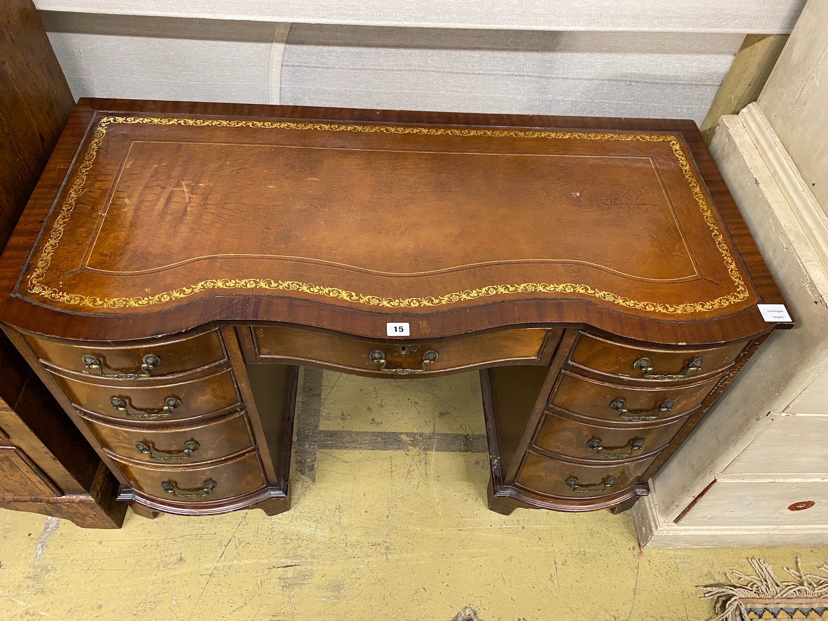 A reproduction mahogany leather topped kneehole writing table, width 114cm, depth 53cm, height 75cm